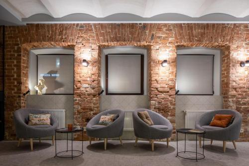 a brick wall with chairs and tables and mirrors at Four Rooms City in Kharkiv