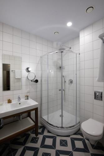 a bathroom with a shower and a toilet and a sink at Four Rooms City in Kharkiv