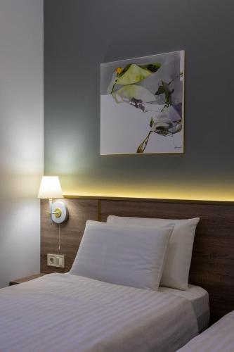 a bedroom with a bed and a painting on the wall at Four Rooms City in Kharkiv