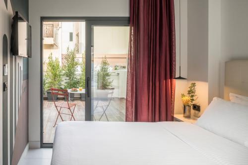 a bedroom with a bed and a sliding glass door at Domus Ariadne in Heraklio Town