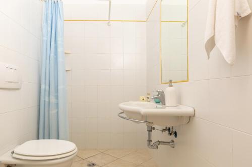 bagno con lavandino, servizi igienici e specchio di Argentario Garden House ad Albinia