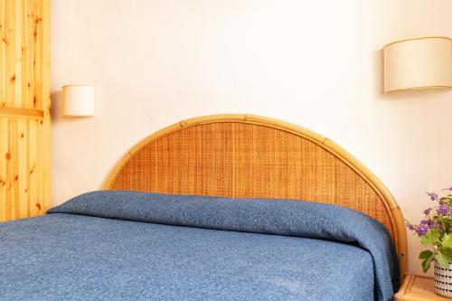 a bed with a wooden headboard in a bedroom at Argentario Garden House in Albinia