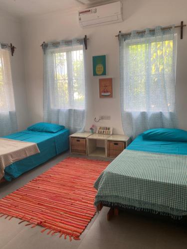 KidotiにあるBig Furaha Villaのベッドルーム1室(ベッド2台、赤い敷物付)