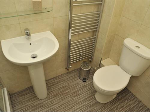 a bathroom with a white toilet and a sink at Hoppers Cottage Guest House in Gateshead