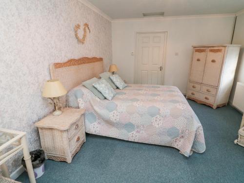 a bedroom with a bed and a table with a lamp at Jasmine at Magnolia Lake in Exeter