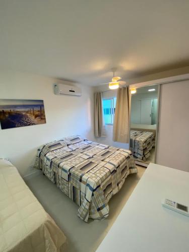 a bedroom with a bed and a mirror at Lindo apto em Arraial do Cabo condomínio Golden Lake in Arraial do Cabo
