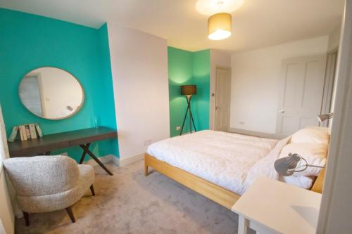 a bedroom with a bed and a desk and a mirror at The Loft Winchester in Winchester
