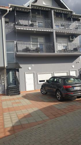 a car parked in a parking lot in front of a building at Apartments Kamenjar in Novi Sad