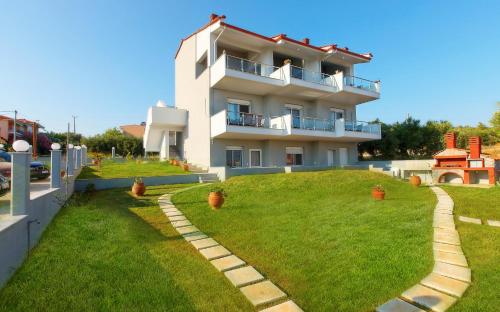 a house on a hill with a green yard at The House Of The Roses in Yerakiní