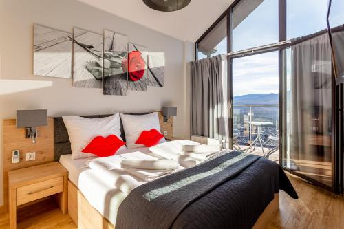 a bedroom with a large bed and a large window at Apartament z widokiem na góry in Szklarska Poręba