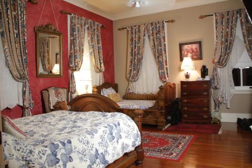a bedroom with a bed and a dresser and a mirror at Flowertown Bed and Breakfast in Summerville