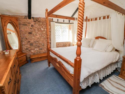 a bedroom with a four poster bed and a mirror at Hayloft at Magnolia Lake in Exeter