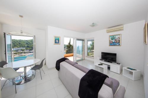 a living room with a couch and a table and a television at Apartment Vista 2 in Dubrovnik