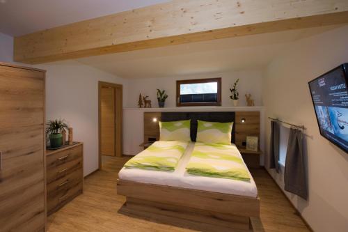 a bedroom with a large bed with yellow sheets at Appartement Neumayer in Viehhofen