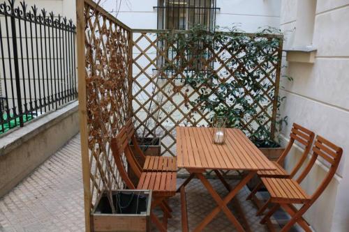 - une table en bois et 2 chaises sur la terrasse dans l'établissement Petit bijou dans le centre de Paris, à Paris