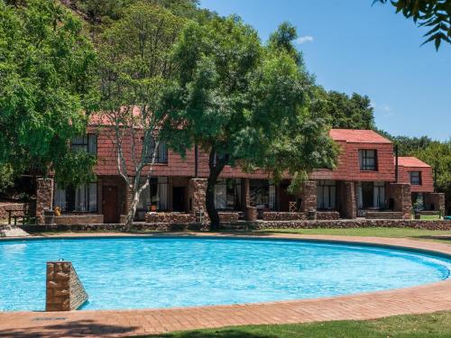 a large swimming pool in front of a house at ATKV Klein-Kariba in Bela-Bela