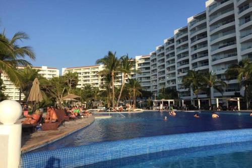 a large swimming pool with people in a resort at Luxury Apartment in Nuevo Vallarta Villamagna Condo in Nuevo Vallarta 