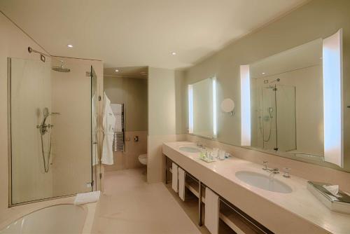 La grande salle de bains est pourvue de 2 lavabos et d'une douche. dans l'établissement NH Linate, à Peschiera Borromeo