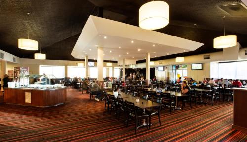 a dining room with people sitting at tables in a restaurant at Nightcap at Gateway Hotel in Corio