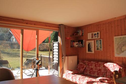 sala de estar con sofá y puerta corredera de cristal en Comfortable Apartment With Terrace In Chamonix en Chamonix-Mont-Blanc