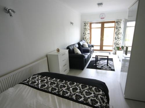 a living room with a bed and a couch at Bryngower House in Llanrhidian