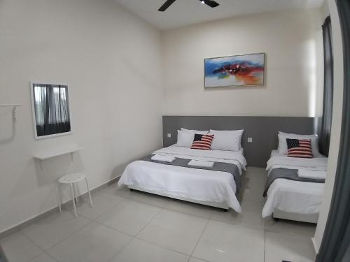 Duas camas num quarto com paredes brancas em New Vacation Homestay @Forest Valley em Kajang