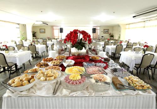 ein Tisch mit vielen verschiedenen Arten von Essen darauf in der Unterkunft San Marco Hotel Brasília in Brasilia