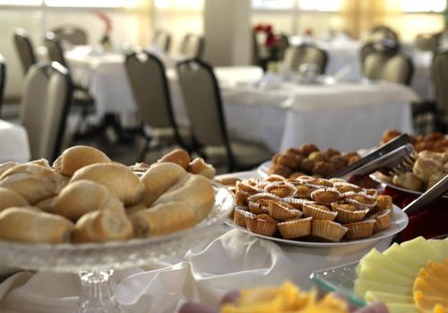 einen Tisch mit Platten aus Brot und Gebäck in der Unterkunft San Marco Hotel Brasília in Brasilia