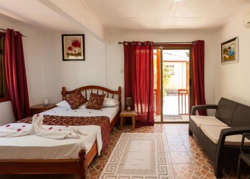 a hotel room with two beds and a couch at Dream Holiday Self Catering in La Digue