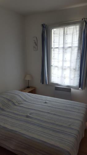 a bedroom with a large bed and a window at Saint Martin in Saint-Martin-de-Ré