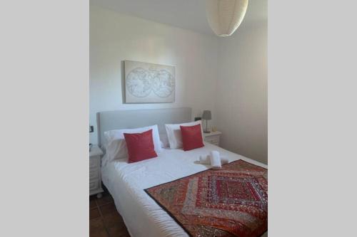 1 dormitorio con cama blanca y almohadas rojas en NATURAL DREAM APARTMENT BLUE WIFI, en Tarifa