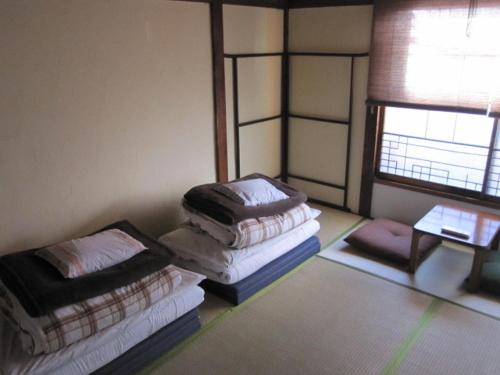 two stacks of pillows in a room with a window at Taito Ryokan in Tokyo