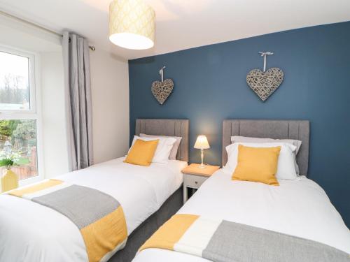 two beds in a room with hearts on the wall at October Cottage in Barnard Castle