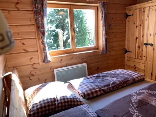 a room with two beds in a log cabin at Bogi Hütte -Falkert in Patergassen