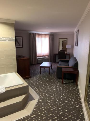 a hotel room with a couch and a table at Wingate by Wyndham Brighton in Brighton
