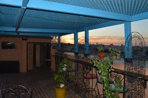 a balcony with a blue roof with plants at Riad Golf Stinia 1 in Meknès