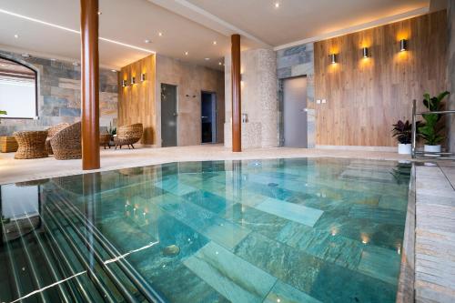 a swimming pool in a house with a glass floor at Hotel Demänová **** in Liptovský Mikuláš