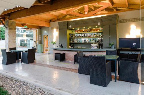 un patio con bar, mesas y sillas en Hotel Lusitano, en Golegã