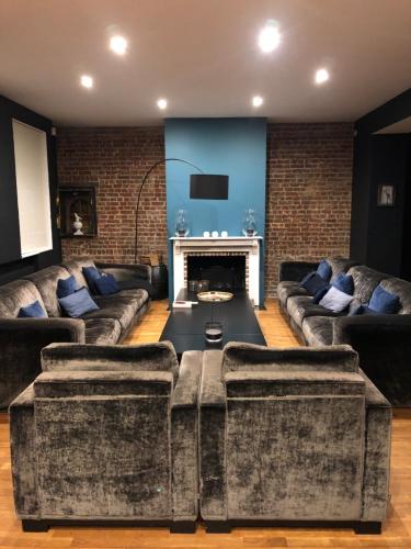 a living room with two couches and a fireplace at Chambres d'Hôtes La Parenthèse in Wambrechies