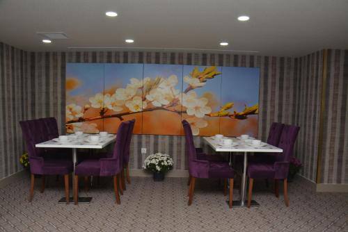 una sala da pranzo con due tavoli e sedie viola di koza millenyum hotel&spa a Ankara