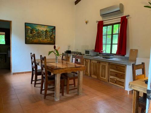 a kitchen with a wooden table and some chairs at Istmo Beach and Jungle Bungalows in San Carlos