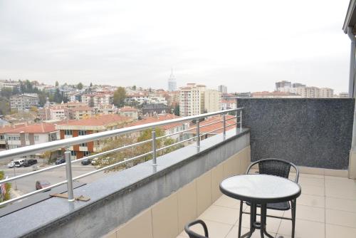 uma varanda com uma mesa e cadeiras e uma cidade em koza millenyum hotel&spa em Ancara