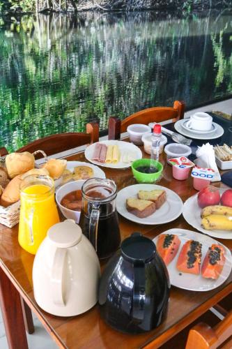 a wooden table with plates of food on it at Pousada Do Suiá in Arraial do Cabo