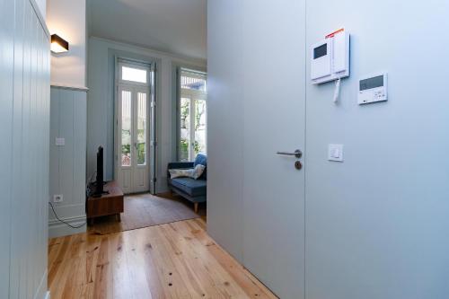 Zimmer mit einer Tür, einem TV und einem Sofa in der Unterkunft Oporto Cozy & Comfy in Porto