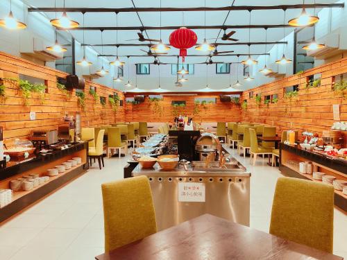un ristorante con tavoli e sedie in una stanza di Wemeet Hotel a Città di Pingtung