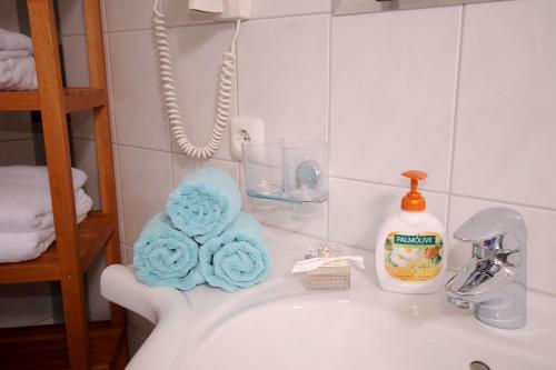 a bathroom sink with towels and a bottle of soap at Landhaus Michael in Mayrhofen
