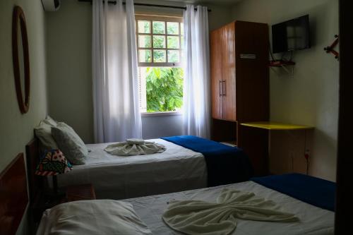 a room with two beds and a window at Pousada Do Suiá in Arraial do Cabo