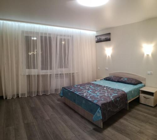 um quarto com uma cama e uma janela com cortinas em НОВАЯ КВАРТИРА на пр. Соборном возле ЗНУ em Zaporozhye