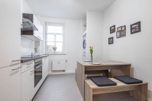 eine Küche mit weißen Wänden und einer hölzernen Arbeitsplatte in der Unterkunft Lieblingsplatz Heroldsberg in Heroldsberg