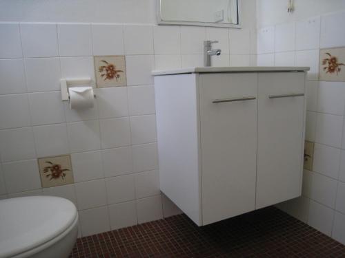 a white bathroom with a toilet and a sink at Country Lodge Motor Inn in Bathurst
